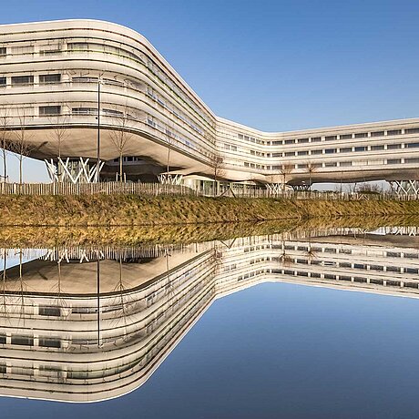 [Translate to Belgian Dutch:] Modern, langgerekt gebouw aan het water.